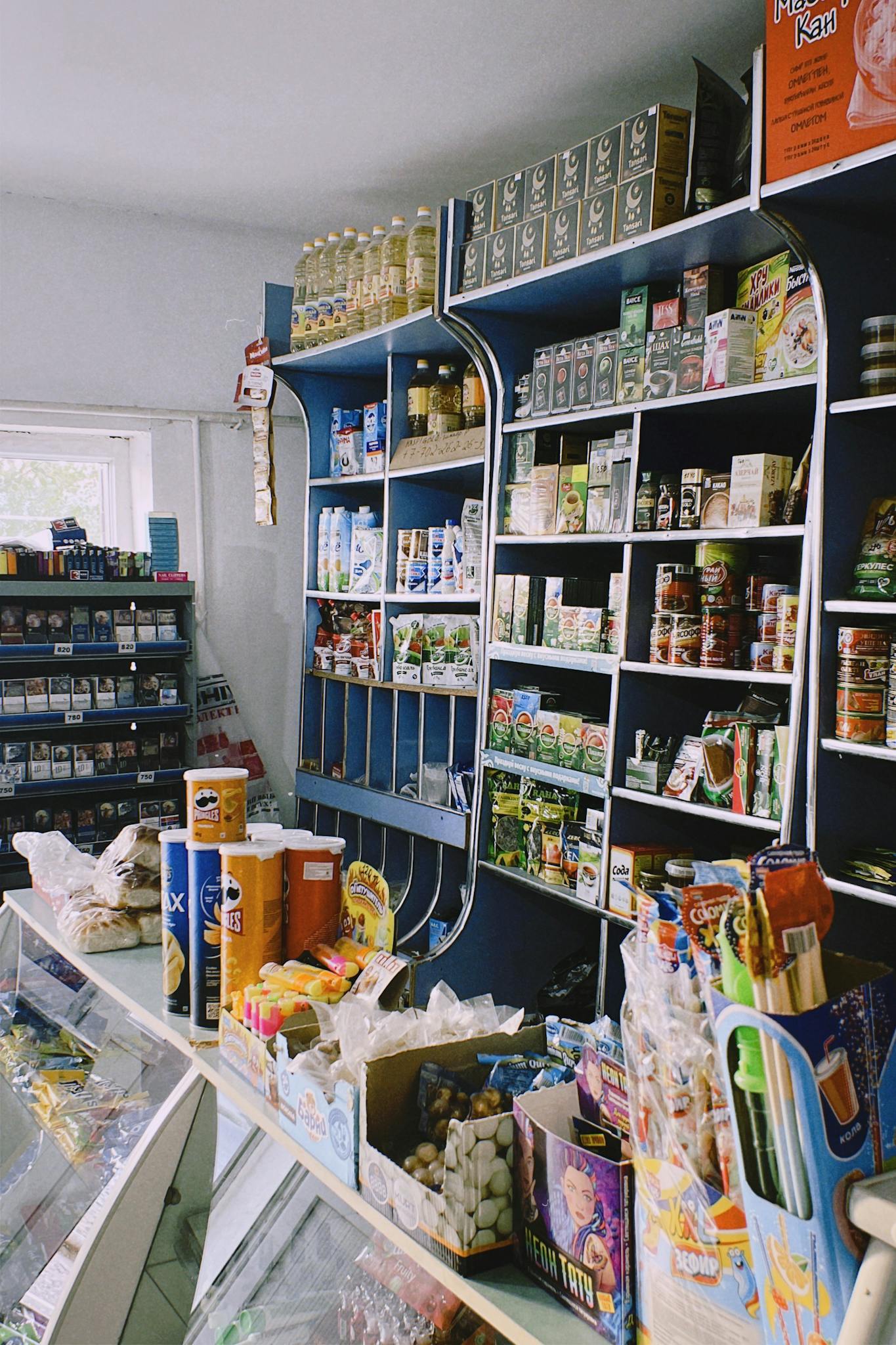 Packed shelves in a Shymkent grocery store with various products on display.